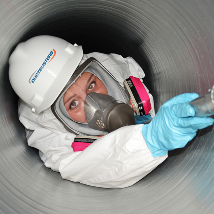 DUCTBUSTERS technician in an air duct cleaning